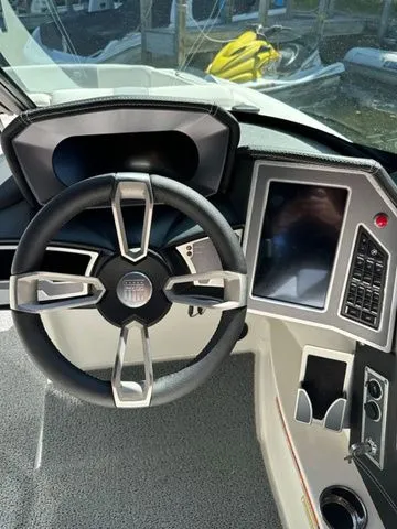 Slide: The Image of 2023 MasterCraft X24 boat dashboard with steering wheel and touchscreen controls. - 11