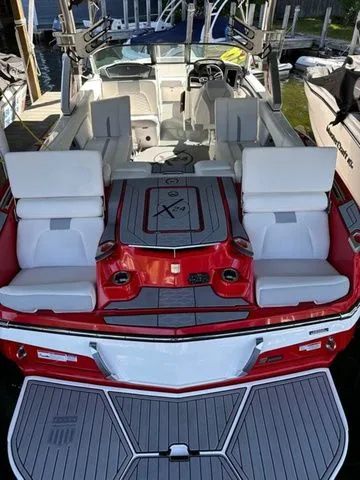 Slide: The Image of 2023 MasterCraft X24 boat with red and white seating, docked at a marina. - 17