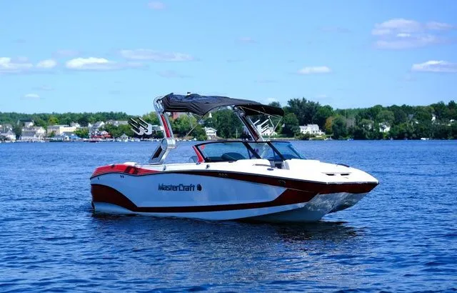Slide: The Image of 2023 MasterCraft X24 boat on a lake under a clear blue sky. - 4