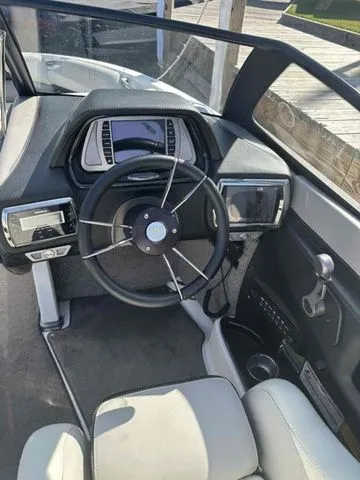 Slide: The Image of 2014 Malibu Wakesetter 23 LSV boat cockpit with steering wheel and dashboard controls. - 5