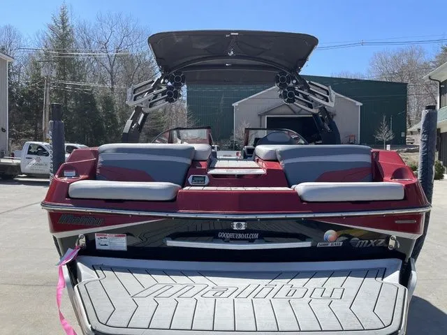 Slide: The Image of 2017 Malibu 22 MXZ boat with new engine and transmission, parked outdoors. - 11