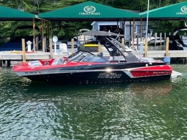 Slide: The Image of 2017 Malibu 22 MXZ boat with new engine and transmission, docked on a sunny day. - 4