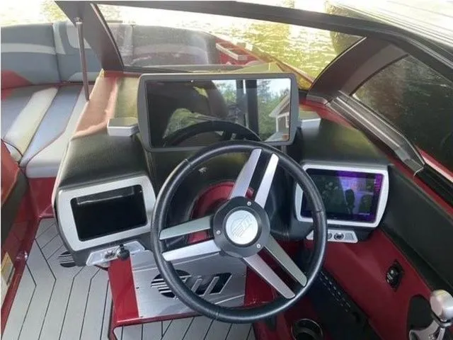 Slide: The Image of 2017 Malibu 22 MXZ boat dashboard with modern controls and steering wheel. - 6