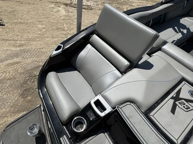 Slide: The Image of 2018 MasterCraft X23 boat interior with gray seating and cup holders. - 11