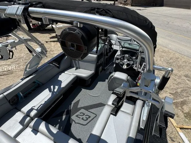 Slide: The Image of 2018 MasterCraft X23 boat interior with seating, steering wheel, and speaker system. - 12