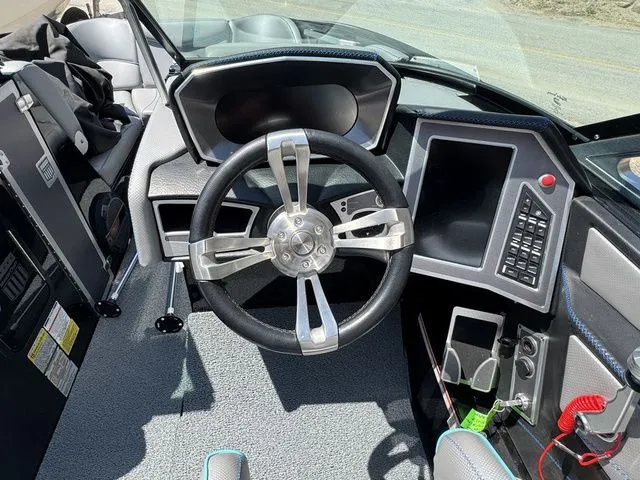 Slide: The Image of 2018 MasterCraft X23 boat dashboard with steering wheel and control panel. - 14