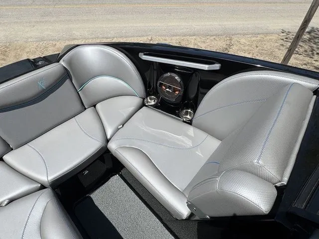 Slide: The Image of 2018 MasterCraft X23 boat interior with gray seating and speaker system. - 17