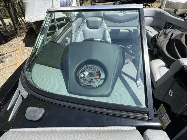 Slide: The Image of 2018 MasterCraft X23 boat interior with speaker, gray seating, and windshield view. - 18