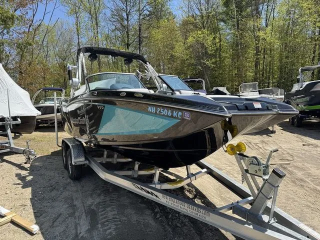 Slide: The Image of 2018 MasterCraft X23 boat on trailer in wooded area, ready for transport. - 5