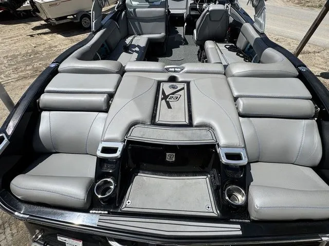 Slide: The Image of 2018 MasterCraft X23 boat interior with luxurious gray seating and cup holders. - 6