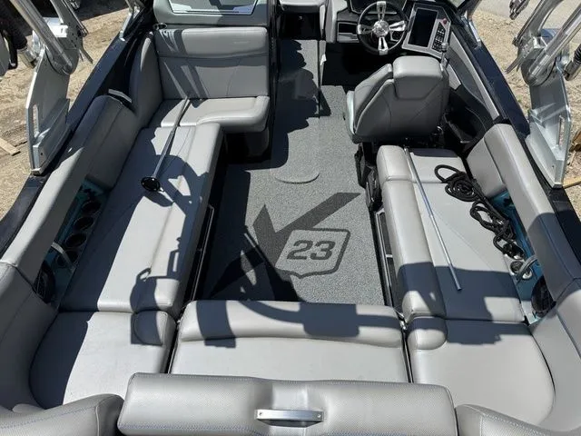 Slide: The Image of 2018 MasterCraft X23 boat interior with gray seating and steering console. - 7