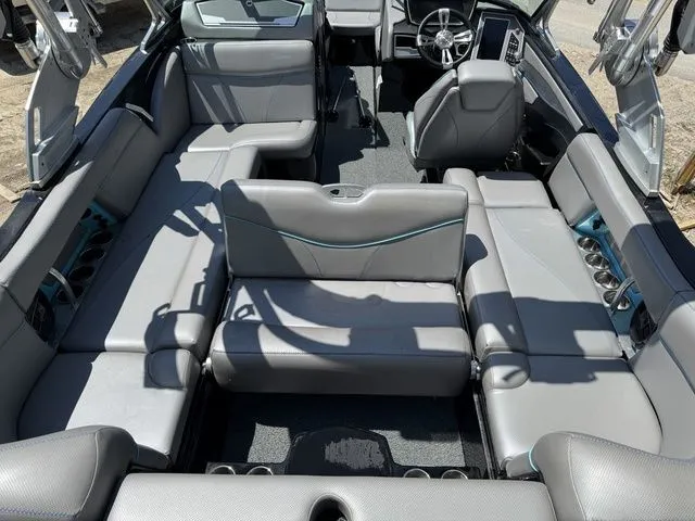 Slide: The Image of 2018 MasterCraft X23 boat interior with gray seating and modern dashboard. - 9