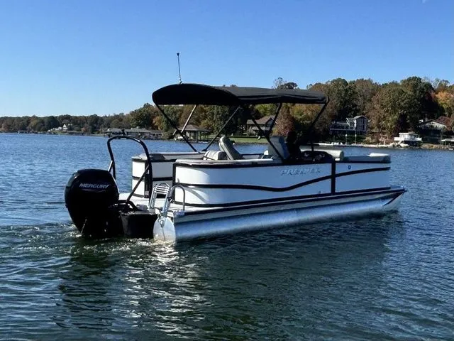 Slide: The Image of 2025 Premier 220 Sunscape RF pontoon boat cruising on a serene lake. - 3