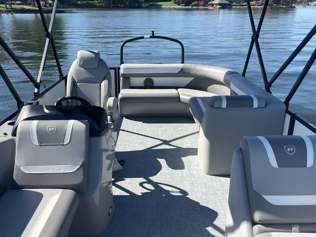Slide: The Image of 2025 Premier 220 Sunscape RF boat interior with gray seating on a calm lake. - 4