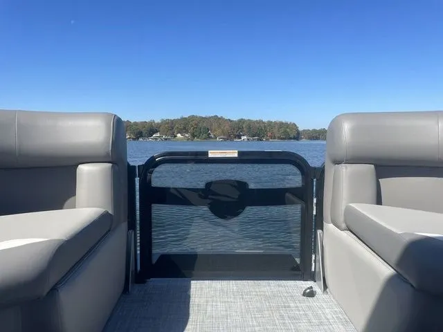 Slide: The Image of 2025 Premier 220 Sunscape RF pontoon boat interior with lake view under clear blue sky. - 7