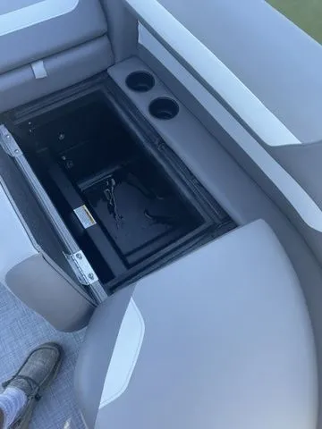 Slide: The Image of 2025 Premier 220 Sunscape RF boat interior with storage compartment and cup holders. - 8