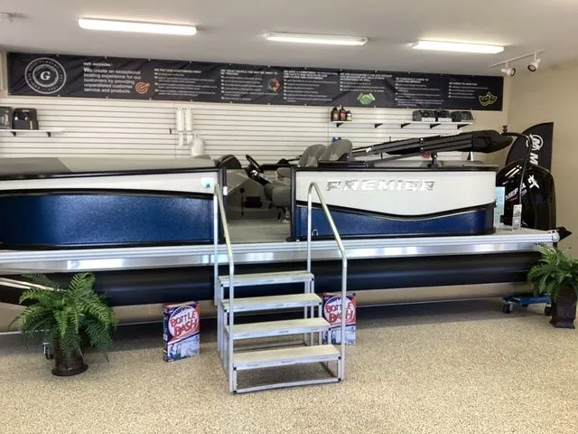 Slide: The Image of 2025 Premier 200 SUNSCAPE RE-CL pontoon boat displayed in showroom with stairs and plants. - 1