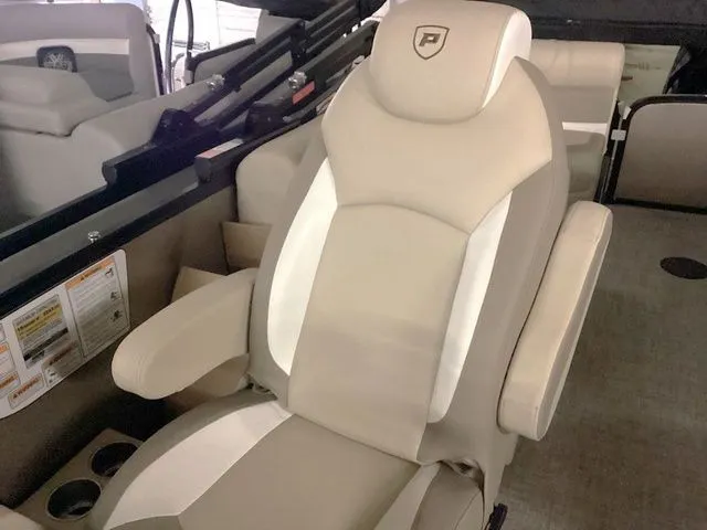 Slide: The Image of 2024 Premier 230 Solaris RF boat seat, beige and white upholstery, armrests, cup holders. - 24