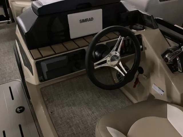 Slide: The Image of 2024 Premier 230 Solaris RF boat dashboard with steering wheel and Simrad display. - 25