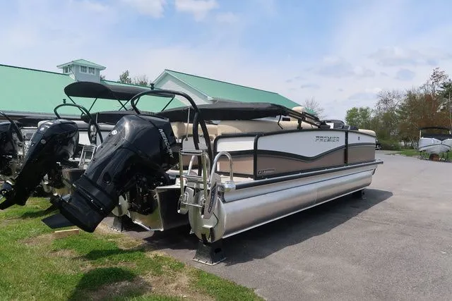 Slide: The Image of 2024 Premier 230 Solaris RF pontoon boat with outboard motor, parked outdoors. - 4