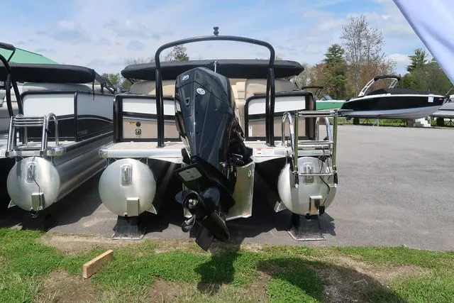 Slide: The Image of 2024 Premier 230 Solaris RF pontoon boat with outboard motor, parked on grass. - 5
