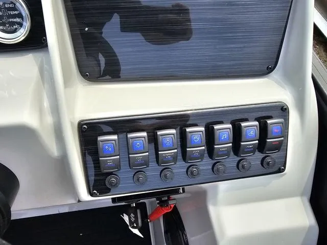 Slide: The Image of Control panel of 2025 Sylvan Mirage 8520 CLZ DH boat with labeled switches. - 12