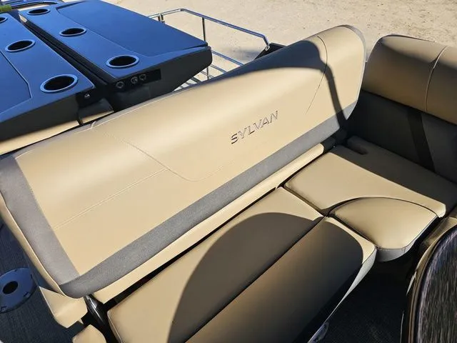 Slide: The Image of 2025 Sylvan MIRAGE X3 DLZ BAR boat seating with cup holders and tan upholstery. - 11