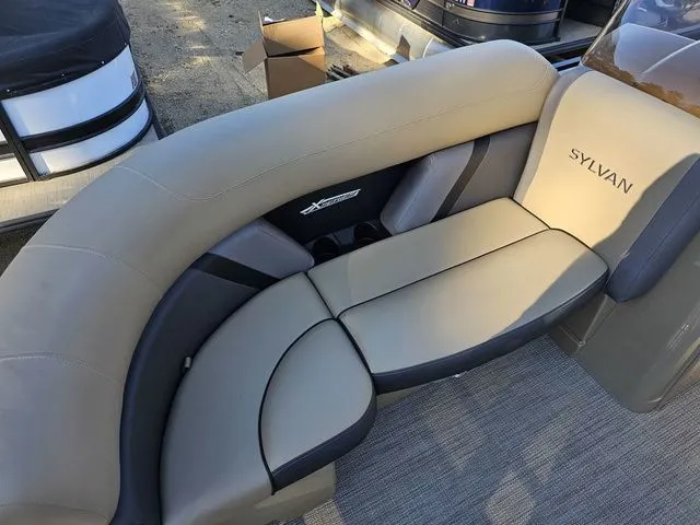 Slide: The Image of 2025 Sylvan MIRAGE X3 DLZ BAR boat interior with beige and gray seating. - 6
