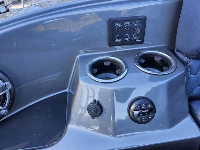 Slide: The Image of 2025 Sylvan M3 CLZ DC boat console with cup holders and audio controls. - 24