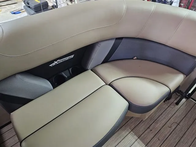 Slide: The Image of 2025 Sylvan Mirage X1 boat interior with beige and gray seating. - 13