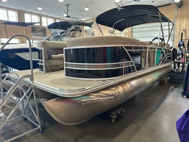 Slide: The Image of 2023 Sylvan 8524 CLZ pontoon boat displayed indoors with canopy and seating. - 1