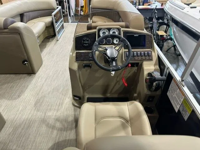Slide: The Image of 2023 Sylvan 8524 CLZ boat interior with steering console and seating area. - 10