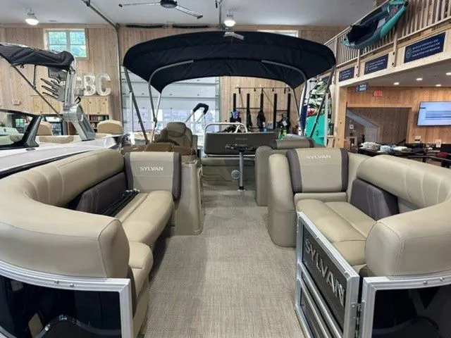 Slide: The Image of 2023 Sylvan 8524 CLZ pontoon boat interior with beige seating and canopy. - 5