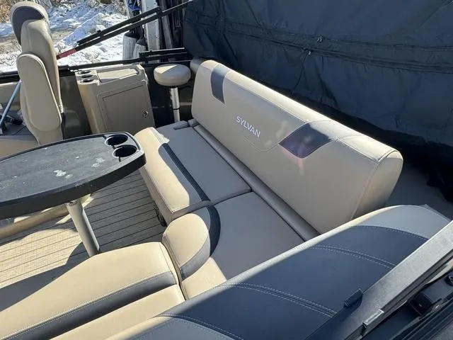 Slide: The Image of Interior of 2023 Sylvan L-3 DLZ BAR pontoon boat with beige seating and table. - 11