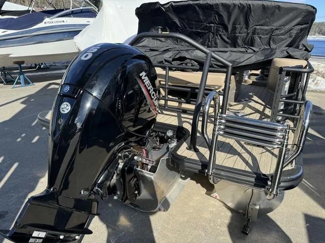 Slide: The Image of 2023 Sylvan L-3 DLZ BAR pontoon boat with Mercury outboard motor, docked outdoors. - 3