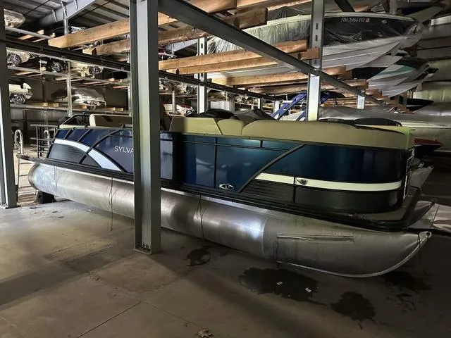 Slide: The Image of 2023 Sylvan L-3 DLZ pontoon boat stored in a warehouse. - 1