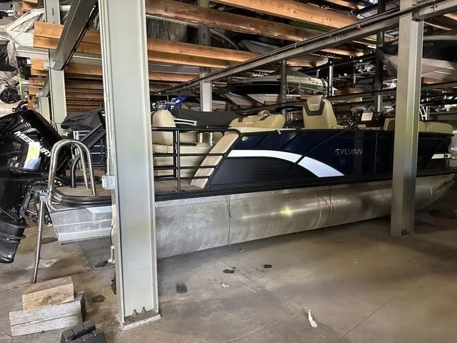 Slide: The Image of 2023 Sylvan L-3 DLZ pontoon boat stored indoors, showcasing sleek design and modern features. - 2