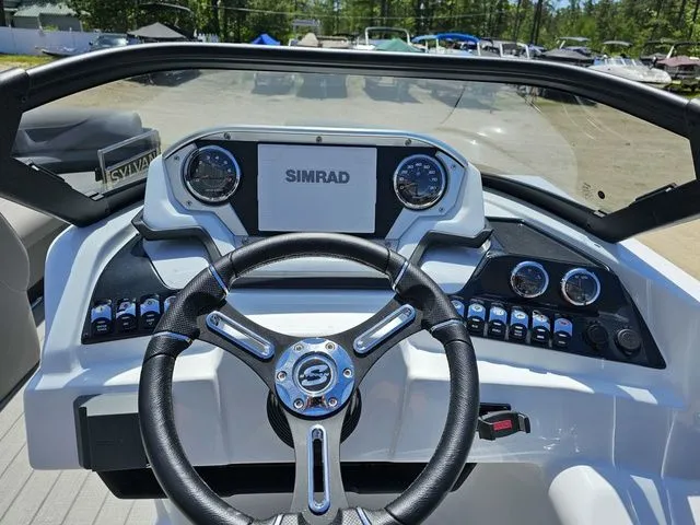 Slide: The Image of 2023 Sylvan S3 LZ boat dashboard with Simrad display and steering wheel. - 14