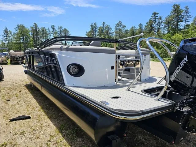 Slide: The Image of 2023 Sylvan S3 LZ pontoon boat with Mercury engine, parked outdoors. - 5