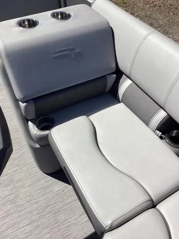 Slide: The Image of 2022 Bennington 24 LSRC boat seating with cup holders, featuring sleek gray upholstery. - 13
