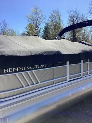 Slide: The Image of 2022 Bennington 24 LSRC pontoon boat with cover, parked outdoors. - 19