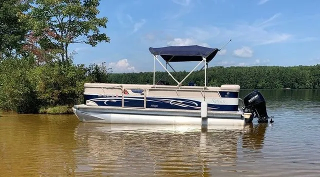 Slide: The Image of 2006 Sylvan Mirage 8520 pontoon boat on a calm lake with trees in the background. - 1