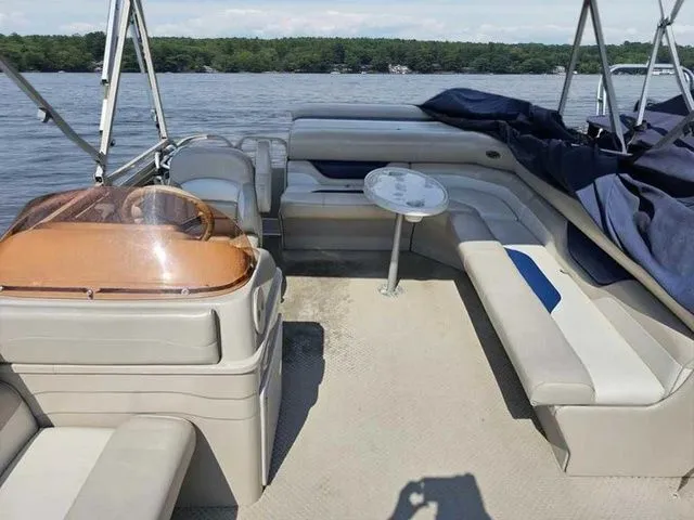 Slide: The Image of 2006 Sylvan Mirage 8520 pontoon boat interior with seating and table on a lake. - 3
