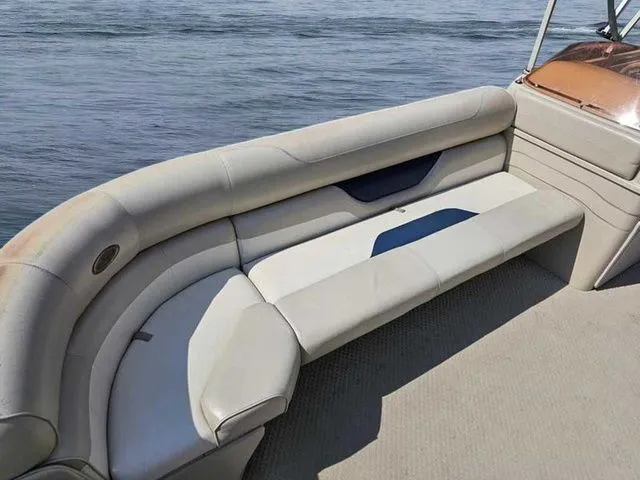 Slide: The Image of 2006 Sylvan Mirage 8520 boat interior with beige seating by the water. - 7