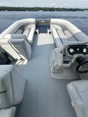 Slide: The Image of 2017 Crest 250 SL pontoon boat interior with spacious seating and modern dashboard on a lake. - 10