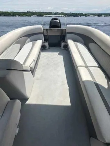 Slide: The Image of 2017 Crest 250 SL pontoon boat interior with spacious seating on a calm lake. - 12