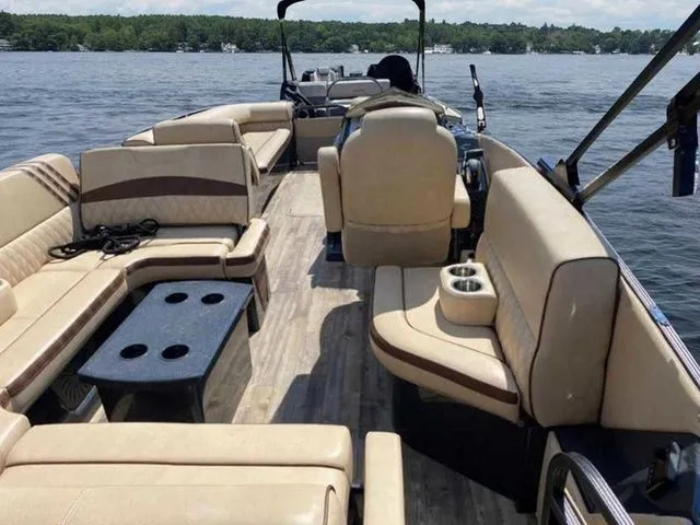 Slide: The Image of 2017 Crest Savannah 250 NX L pontoon boat with spacious seating on a calm lake. - 6