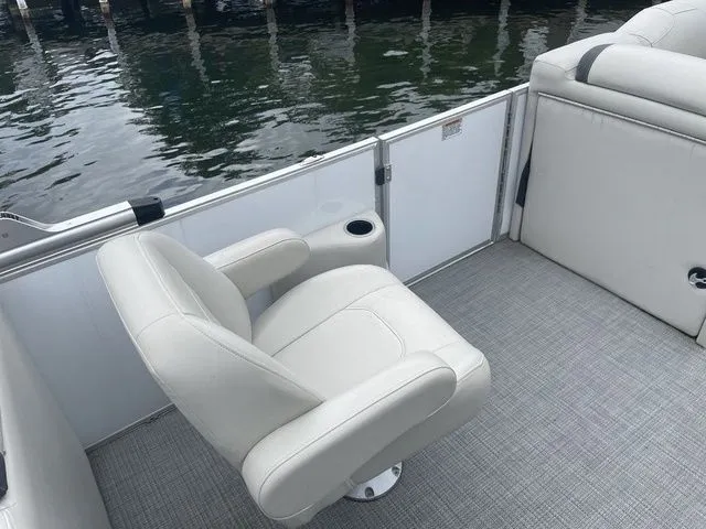 Slide: The Image of 2022 Sylvan 8522 LZ boat interior with white seating and water view. - 7