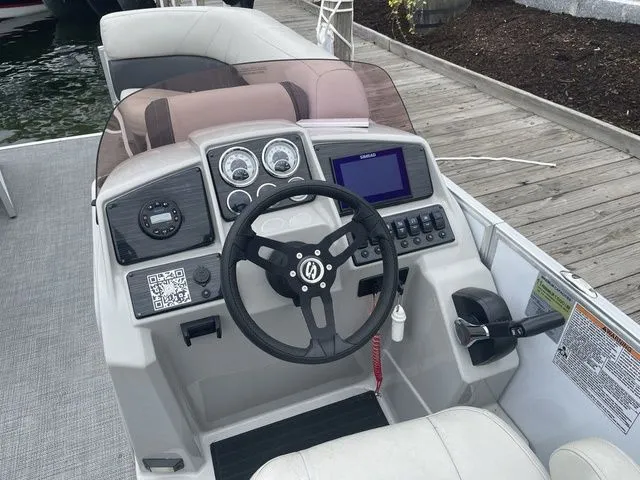 Slide: The Image of 2022 Sylvan 8522 LZ boat dashboard with steering wheel and control panel. - 8