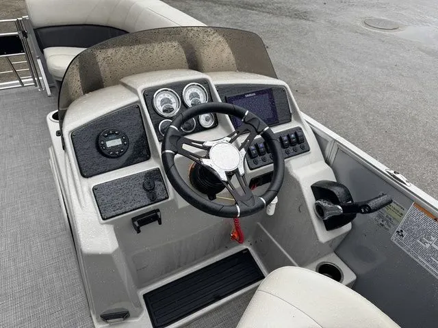 Slide: The Image of 2022 Sylvan 8522 LZ boat dashboard with steering wheel and control panel. - 16
